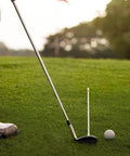 Golfer using Golf Alignment Rods Swing Trainer Aid for Consistent Golf Shots with a club and ball on a grassy course.