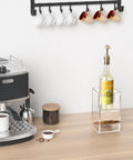 Clear acrylic Two Tier Upright Cup And Condiment Organizer with bottle and coffee machine on countertop