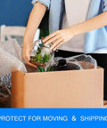 Person using Bubble Cushioning Wrap Rolls 2 Pack 12 Inch By 72 Feet Three Sixteenths Inch Air Bubbles Perforated Every 12 Inches for packing glassware in a box