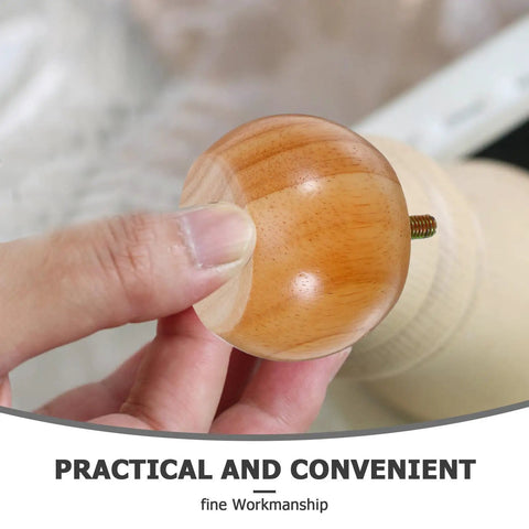 Hand holding a bun foot from Round Wood Furniture Leg Replacement Set 4 Heavy Duty Bun Feet 5cm Height Boost Unfinished Modern Style.