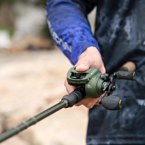 Angler holding Six Foot Eight Inch Medium Heavy Baitcasting Rod And Reel Combo with Right Hand Retrieve in blue gear.