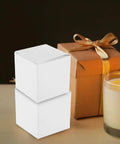 Square White Cardboard Boxes With Buckle Bottom For Candles And Jewelry Packaging Ideal For Small Biz Shipping in a cozy setup.