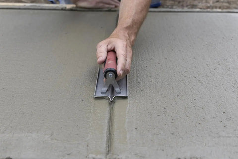Using Stainless Groover from Concrete Starter Tool Kit In Tough Canvas Bag With Six Essential Tools Including Finishing Trowel, Magnesium Hand Float, Stainless Groover, Curved Edger, Wood Float, Margin Trowel, Made In USA CTK2 on wet concrete surface.