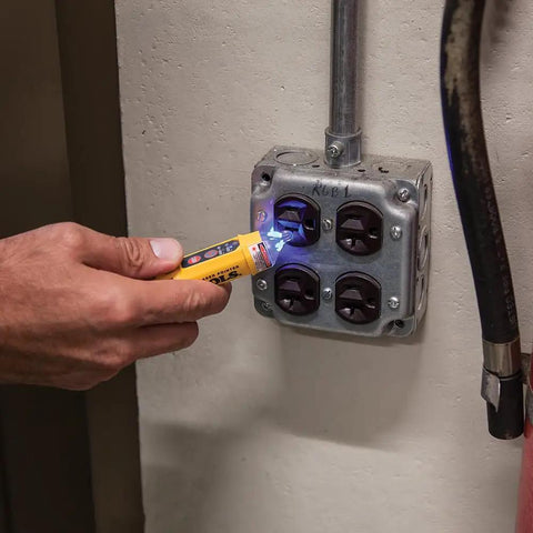 Hand using NCVT5KIT Electrical Test Kit With Dual Range Non Contact Voltage Tester Laser Pointer And GFCI Receptacle Tester for voltage check