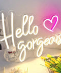 Hello Gorgeous Neon Sign For Girls Bedroom Wall Decor LED Light With Warm White Glow Perfect For Birthday Parties Weddings And Gifts 16.7x12.3 Inches Great Gift Idea displayed with flowers