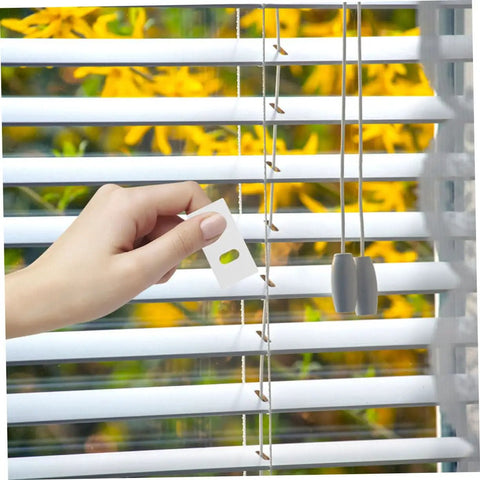 Hand applying a white repair tab from the Vertical Blinds Repair Stickers Kit 50 Pieces No Fuss Easy DIY Fix For Damaged Slats