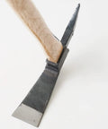 Close-up of One-Handed Pick Mattock For Garden Work Heavy Duty Cruciform Hand Tool showing metal head and wooden handle.