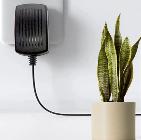 AC DC Power Adapter Charger For Aura Heal AHP1 30W Shiatsu Foot Massager plugged in, showing cable next to a plant
