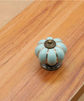Sky blue ceramic pumpkin cabinet knob on wood surface from 5 Pack Retro Vintage Ceramic Pumpkin Cabinet Knobs Set For Kitchen Cabinets Drawers Dresser Cupboard Pull Handles Includes 3 Kinds Of Screws Sky Blue Enhances Vintage Charm For Furniture With Easy Install And Durable Gloss Finish