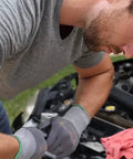 Man wearing Maxiflex PIP Large Ultimate Micro Foam Nitrile Coated Work Gloves with Nylon Liner, working on car engine.