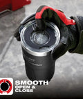 Gloved hand holding Packout Insulated Tumbler 890 Ml Black With Two Wall Vacuum Insulation and Twist to Lock Connectivity.