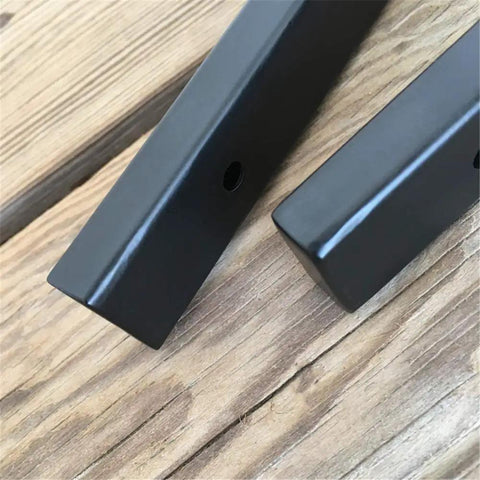 Close-up of Heavy Duty Wall Mounted L Shape Shelf Brackets Two Pack Slick Black Finish Rust Proof Steel on wood surface.