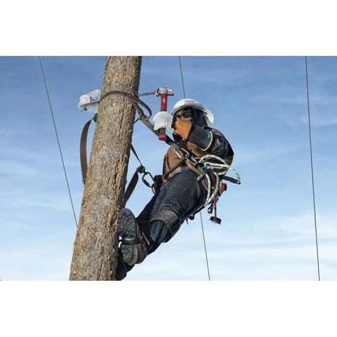 Absolute Beast Heavy Duty 4In1 Lineman Hammer 36 Oz Strike Built Different For Electricians And Job Site Pros Tough As Nails With Grippy Handle in use by a worker on a tree.
