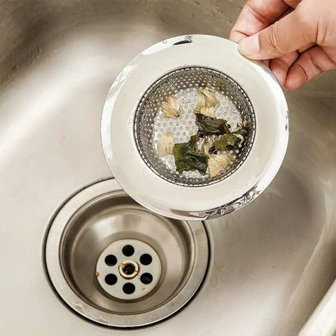 Hand holding Set Of 2 4.5 Inch Diameter Stainless Steel Kitchen Sink Basket Strainer with food particles near sink drain