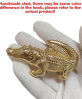 Gloved hand holding gold crocodile-shaped cabinet knob from Crocodile Shaped Cabinet Knobs Set Of 4 In Zinc Alloy Decorative Drawer Pulls For Dresser Cabinet And Closet Vintage Gold Hardware With Single Hole Mount And Rust Resistant Animal Handles.