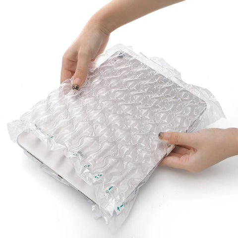 Hands using Bubble Cushioning Wrap For Packing 11.8x164 Ft With Pump to protect a tablet, showing clear air columns.