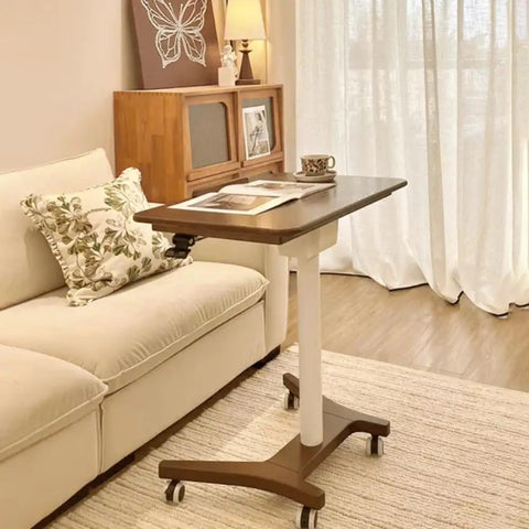 No Drama Roll Mobile Standing Desk Featuring Smooth Gas Lift Adjustments And A Tilt Tray Top Portable Laptop Desk next to couch with decorative pillow.