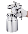 Hardcore Pro Level Pneumatic Spray Gun With Slick Adjustable Valve And Killer Stainless Steel Nozzle For Smooth Auto Paint Jobs Up To 1000 Ml Capacity tight antiskid grip held in a gloved hand.