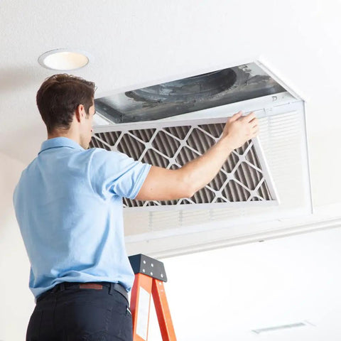 Person installing MERV 8 Pleated Replacement Air Filter 14x18x1 for AC and furnace, enhancing indoor air quality.