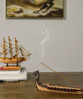 Hand Carved Dragon Boat Incense Holder For Stick Incense Burners on wooden table with smoke rising, distinctive dragon censer ornament.