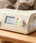 Beige CPAP machine with digital display and control knob on wooden table