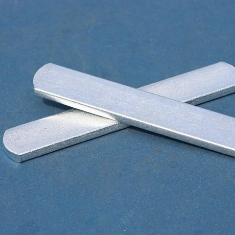 Close-up of two metal flat bars overlapping on a blue surface