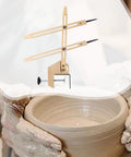 Portable Pottery Throwing Gauge Straight Up Essential For Beginners used on a pottery wheel with wooden measuring arms.
