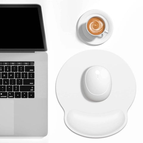 Ergonomic Mouse Pad With Memory Foam Wrist Rest For Pain Relief And Fatigue Reduction Ultra Smooth Surface And Non Slip Base Go To Choice For Gaming Office And Laptop Use White next to laptop and coffee cup.