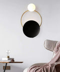 Fresh Modern LED Wall Sconce With Sturdy Iron Body, Up And Down Illumination Creates A Chill Ambient Vibe For Bedrooms, Bathrooms Or Halls, Warm Wash Light Is An Instant Upgrade For Any Home Setup Today. Black circular sconce with gold accents.
