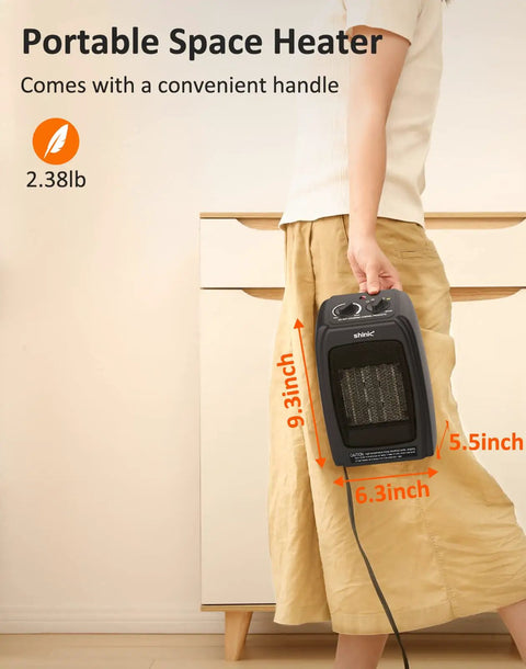 Person holding compact ceramic space heater with 1500W and 900W modes, 1 second fast heat, black, with handle, next to drawer.