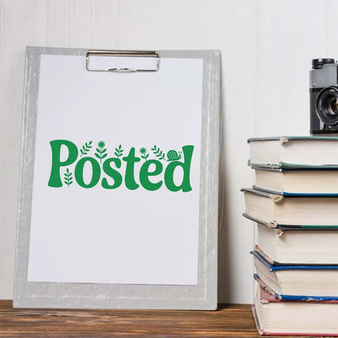 "Posted" stamped in green on paper with Go To Small Duo Hand Stamp For Mail And Parcels near a stack of books and a camera.