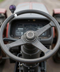 Ball Shape Steering Wheel Spinner Knob for Tractors Forklifts and Lawn Mowers One Hand Turn Aid Grip Suicide Style Power Handle Dark Purple Durable Resin and Metal Construction installed on a tractor steering wheel.