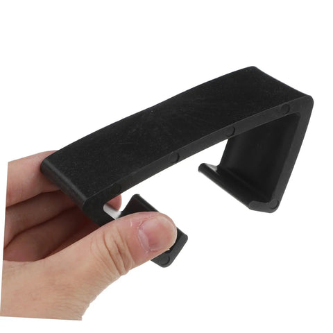 Close-up of a hand holding a black clip from 4 Pack Outdoor Wicker Sofa Connector Clips For Sectional Chairs Rattan Furniture Fasteners Skid Design Cushion Support That Keeps Cushions From Sliding And Wobbling On Patio Furniture.