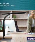 Boss Level LED Desk Lamp With Clamp, 31.5-inch arm, modern office setting, woman stands near desk, sleek black design