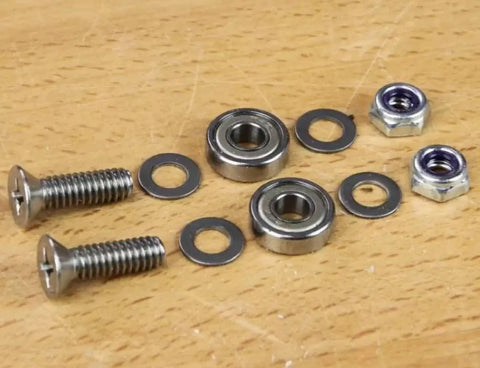 Self Centering Base Plate Kit With Roller Bearings For Universal Router Base Plates showing screws and bearings on wood surface