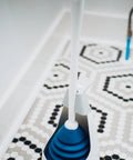 Top Shelf Toilet Plunger With No Drip Carrying Caddy And Suction Lock Seal, blue and white, on hexagonal patterned floor.