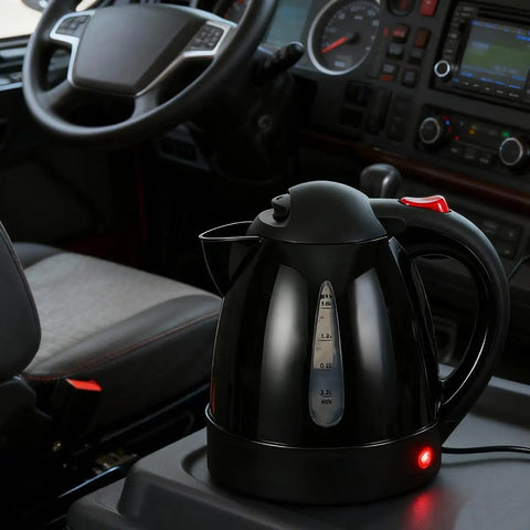 RigReady 24V 250W Portable Electric Kettle For Trucks And Rv on a console, black design, auto shutoff, 1 liter capacity.