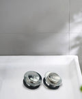 Bathroom Silver Pop-Up Bathtub Waste Drain-Plug, Alloy and Brass Floor Drain for Tub, Water-Tight Seal Push Button Mechanism(2pcs) on white tub surface.