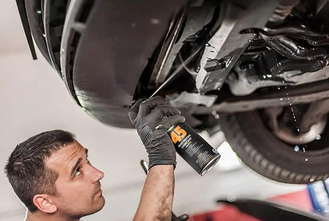 Mechanic applying Penetrating Lubricant For Metal Moving Parts, 17 Oz Can, Heavy Duty Oil That Slips In To Reduce Friction on car's underside