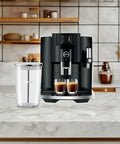Next Level 5th Gen Automatic Smart Coffee Machine Bundle Featuring Piano Black Finish Plus Matching Glass Milk Frothing Container on marble countertop