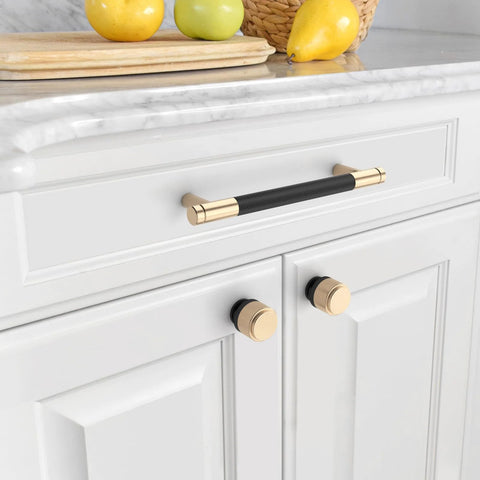 Image of 10 Pack Matte Black And Gold Knurled Cabinet Knobs installed on white kitchen cabinets, featuring zinc drawer knobs with durable hardware.