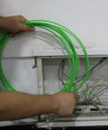 Person holding Heavy Duty Plastic Coated Steel Fish Tape 3Mm 49Ft Wire Puller for through wall wiring.