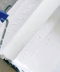 Pro Grade White Fiber Paint Roller Sleeve For Walls With No Fuss Washable Refill Design Featuring Ridiculously Smooth Roll Texture And Dependable Small Size Covers For Quick Home Glow Up, close-up of white roller in paint tray.