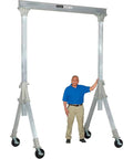 Portable Adjustable Height Aluminum Gantry Crane Lightweight Workshop Hoist With No Fuss Setup Easy Lift Gear Without Breakin Sweat For Tight Garage Bays next to a man, showing height and sturdy base.