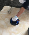 Heavy Duty 8 Inch Glass Suction Cup With Metal Handle lifting a large tile, demonstrating easy grip design and strong suction.