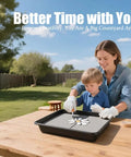 Adult and child crafting with square stepping stone mold on outdoor table, smiling and engaged.