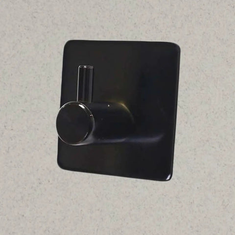 Rock Solid Black Stainless Steel Adhesive Wall Hook For Coats Towels And Umbrellas With No Hassle Peel Stick Mount on smooth surface.