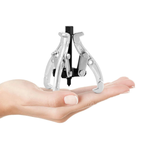 Hand holding Beefy 3 Inch Gear Puller With 3 Reversible Jaws, Drop Forged Cr-V Steel, Heat Treated, 3 Ton Capacity, Chrome Plated Jaws, Black Phosphated Drive Screw, Pro Grade Auto Repair Tool For Cars And Machinery
