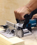 Person using Plate Joiner For Quick, Precise Biscuit Joinery With Five Point Six Amp Motor And Eleven Thousand RPM, Cast Aluminum Pivot Fence.