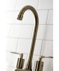 Close-up of Serena Two Handle Deck Mount Bar Faucet in Antique Brass with high spout, installed against white tile.